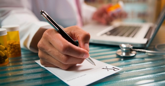 doctor writing on a prescription notepad
